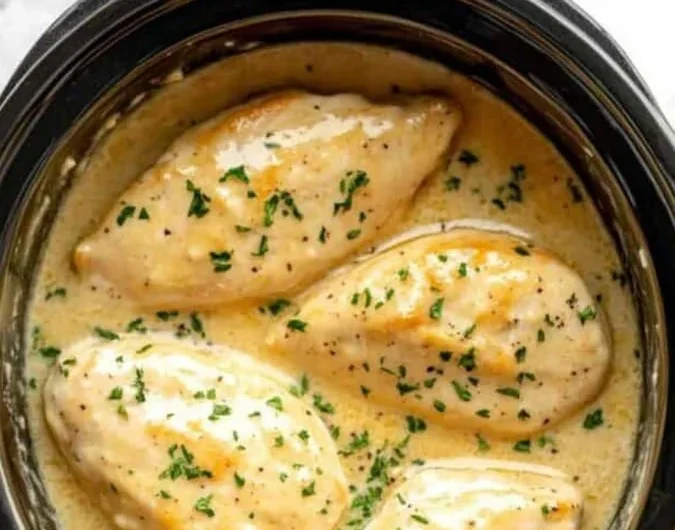 Delicious crockpot creamy garlic parmesan chicken served with herbs.