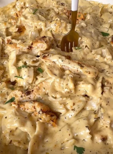 Bowl of dairy-free Chicken Alfredo topped with parsley and chicken slices.