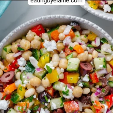 A colorful dense bean salad with various beans and fresh vegetables.