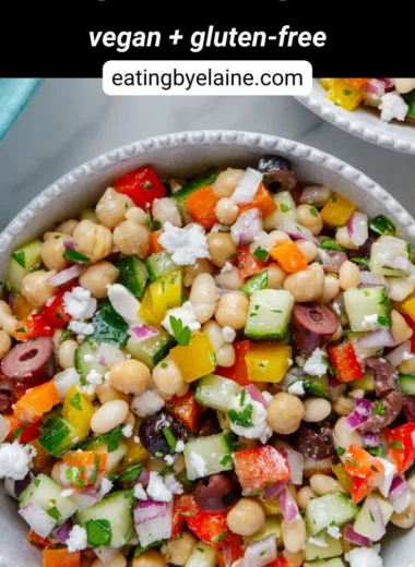 A colorful dense bean salad with various beans and fresh vegetables.