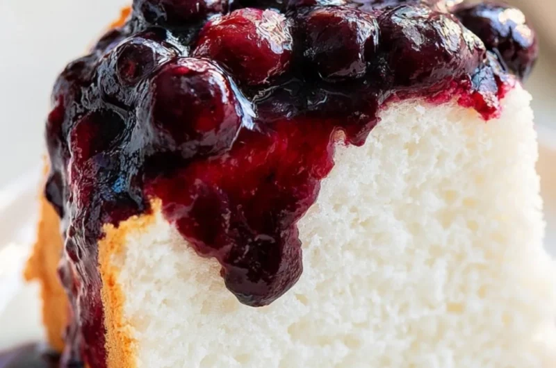 Delicious homemade Angel Food Cake on a serving plate with fresh berries