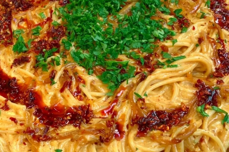 Creamy caramelized onion pasta dish with herbs and cheese