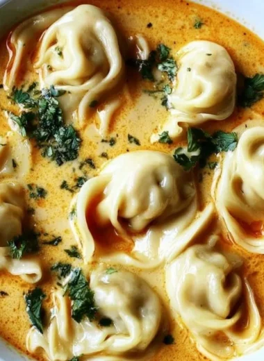 Bowl of creamy Thai dumpling soup garnished with herbs and spices