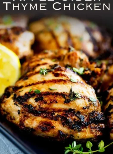 Grilled Apple Cider Thyme Chicken garnished with fresh thyme and served on a platter.