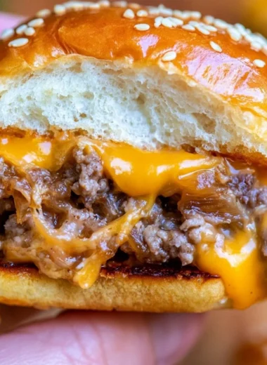 Plate of juicy cheeseburger sliders garnished with fresh toppings