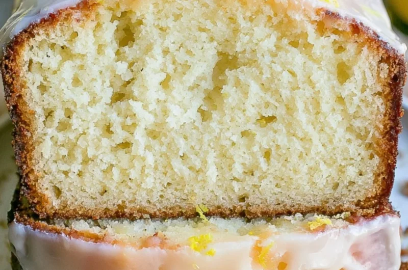 Moist lemon pound cake served on a plate, garnished with lemon slices