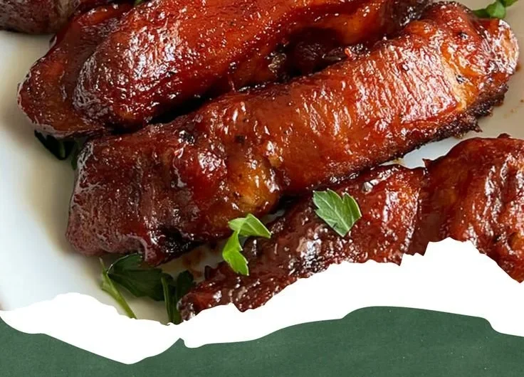 Oven-roasted country-style pork ribs garnished and served on a plate