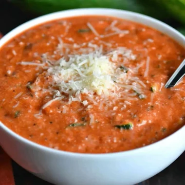 Delicious Zucchini Tomato Soup garnished with fresh basil and served in a bowl.