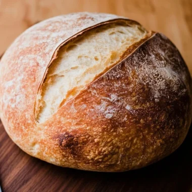 Loaf of freshly baked beginners sourdough bread on a wooden board