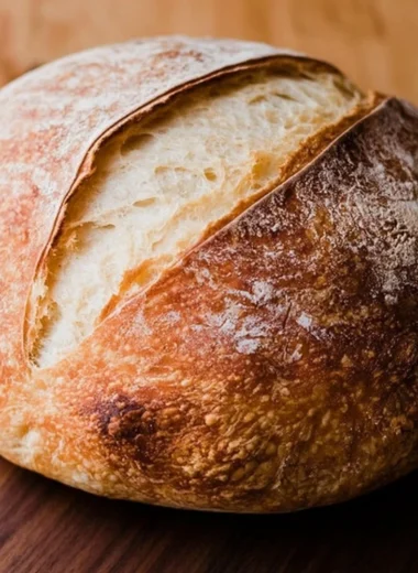 Loaf of freshly baked beginners sourdough bread on a wooden board