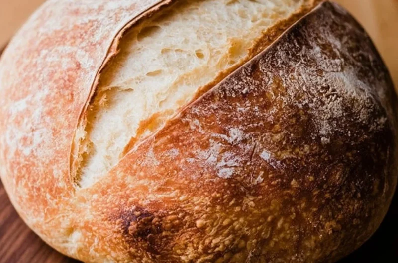Loaf of freshly baked beginners sourdough bread on a wooden board