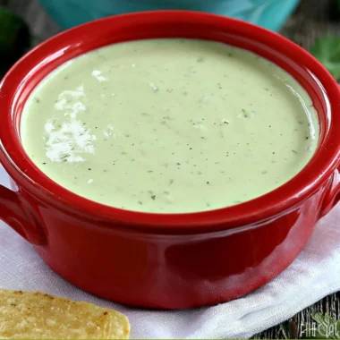 Cozy creamy jalapeño dip in a bowl garnished with herbs.