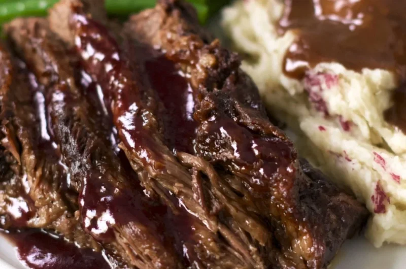 Delicious Crock Pot Chuck Roast served with vegetables and gravy.