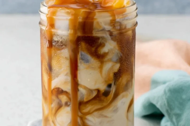 Homemade caramel iced coffee in a glass with ice and whipped cream
