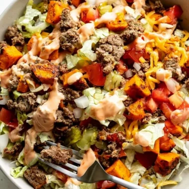 Delicious sweet potato burger bowl topped with fresh vegetables and spices.