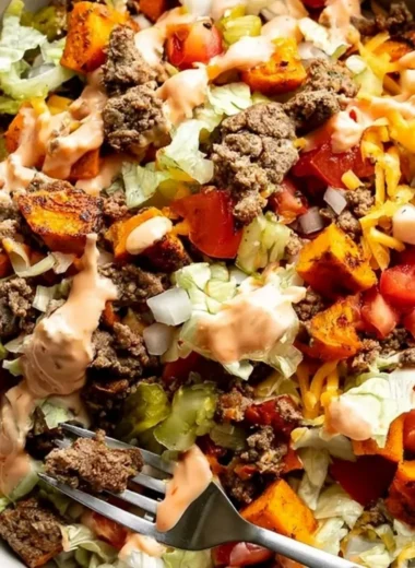 Delicious sweet potato burger bowl topped with fresh vegetables and spices.